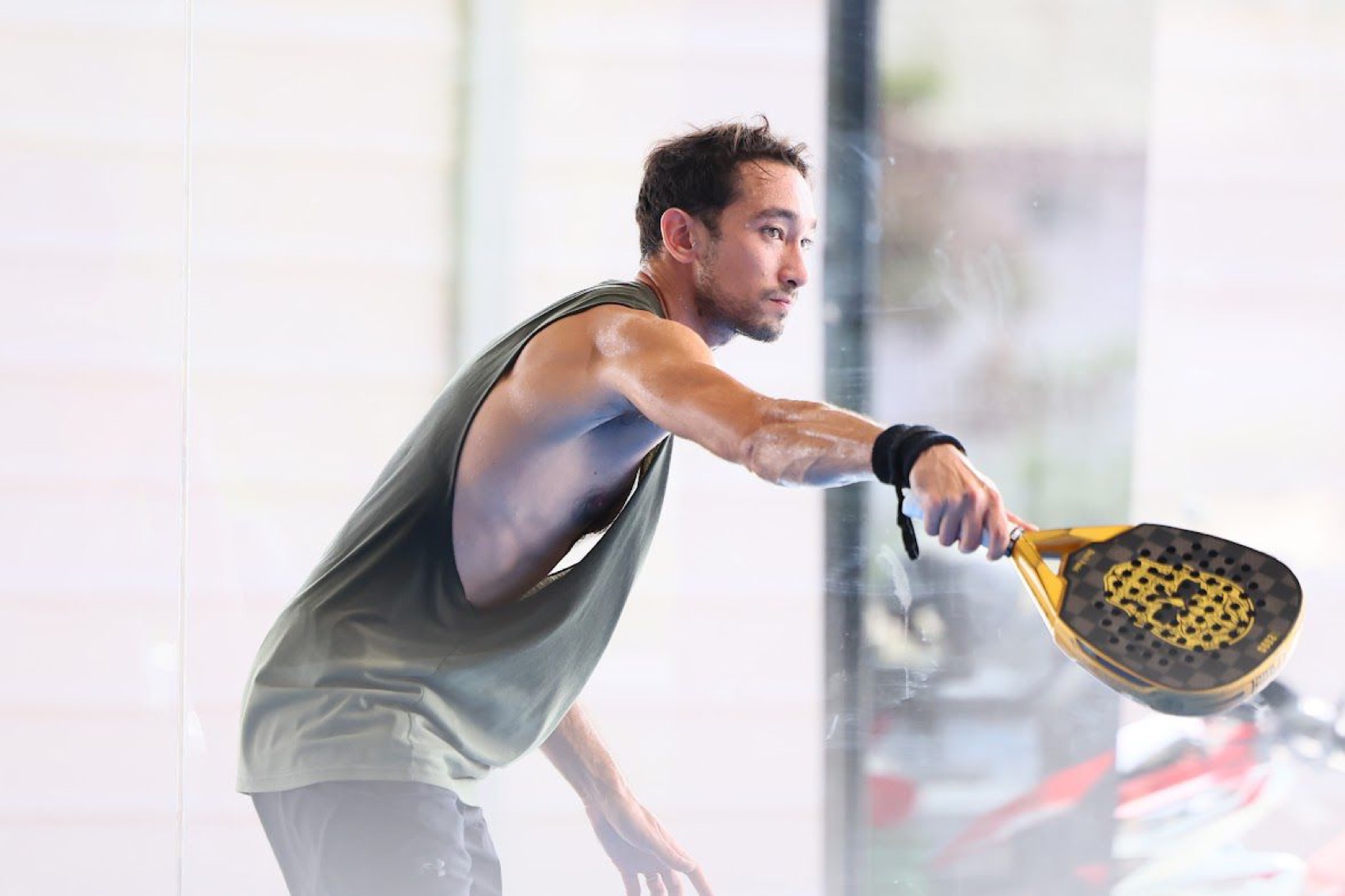 Warren, padel coach at Chilli Padel Jomtien Pattaya, mid-action with a gold racket